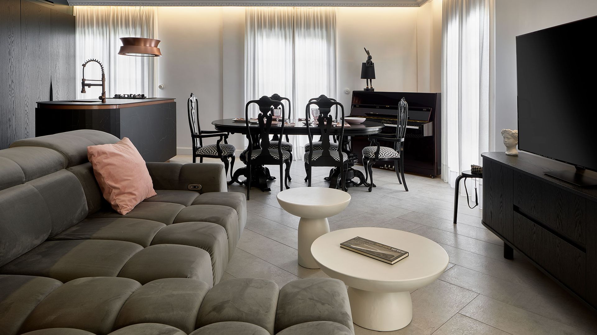 Salón comedor y cocina, en colores oscuros, mueble de television negro, mesas auxiliares blancas