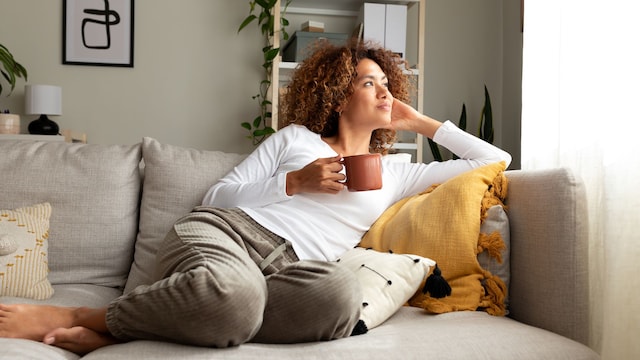 mujer relajada tomando un té en el sofá