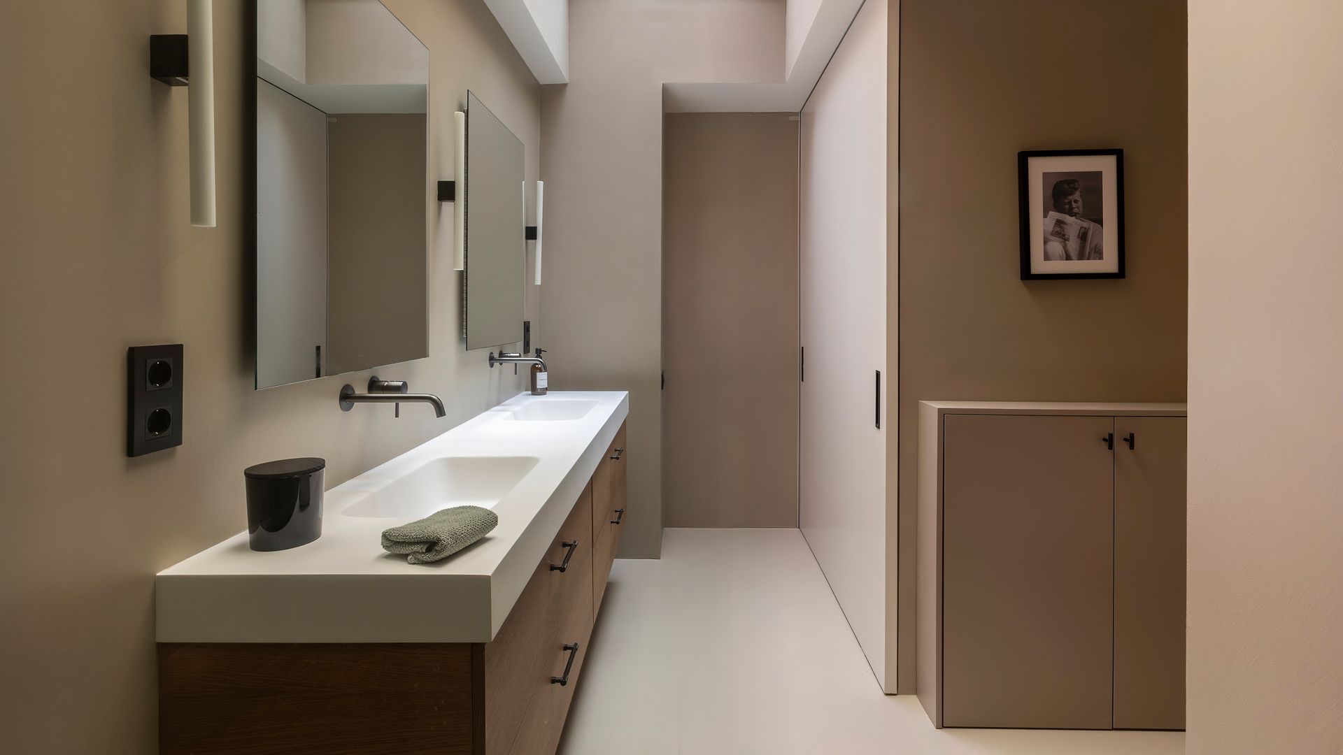 Baño en colores tierra, con lavamanos y espejo doble, mueble bajolavabo de madera con encimera blanca