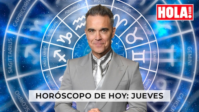 Robbie Williams en primer plano, de fondo, la rueda del zodiaco