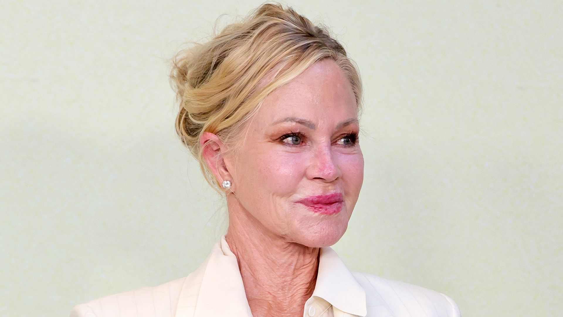 Melanie Griffith en la premiere de Splitsville en Los Ángeles con traje de chaqueta blanco y recogido de lado