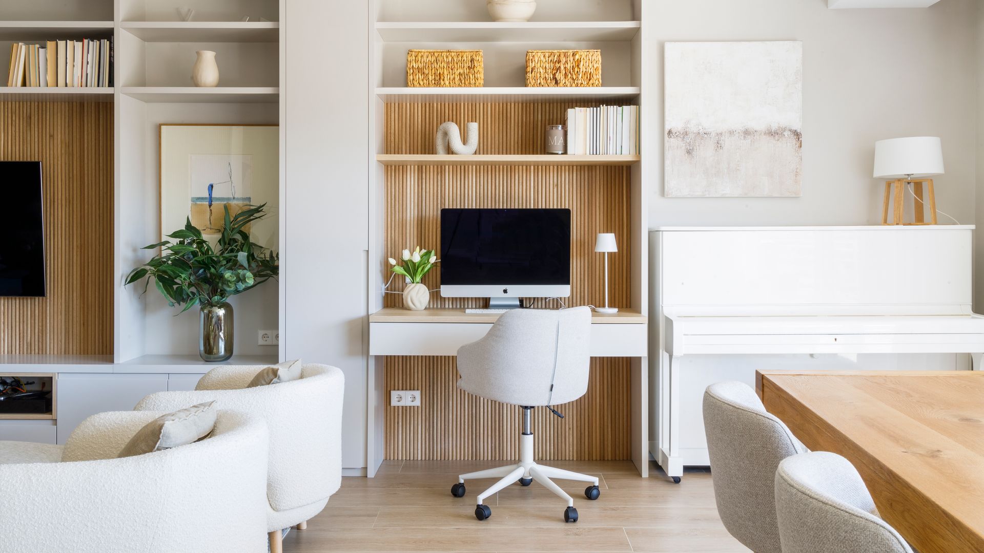 Salón comedor con despacho integrado en el mueble de la televisión, sofá blanco y muebles de madera y blancos