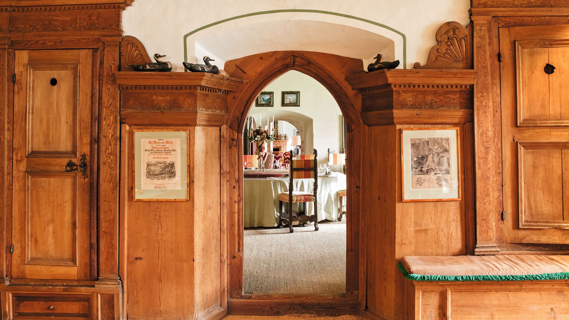 Salón con muebles de madera antigua, arco de entrada y comedor visible