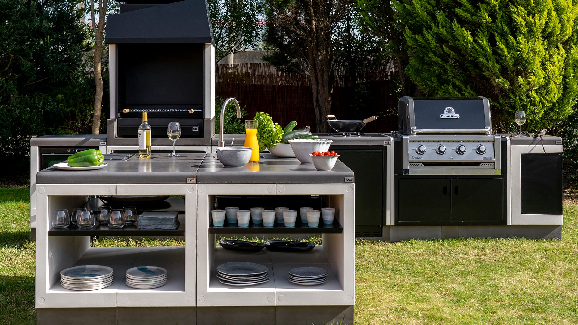 Cocina de exterior en jardín con isla, barbacoa y vitrina