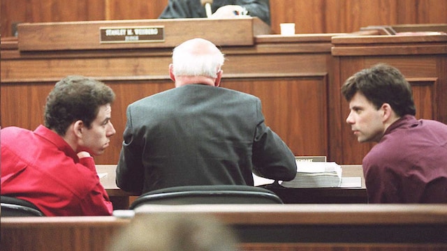 Plano medio de Erik Y Lyle Menendez conversando durante el juicio