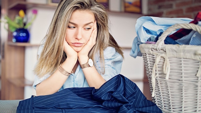 Mujer con plancha pendiente aburrida y cansada de planchar