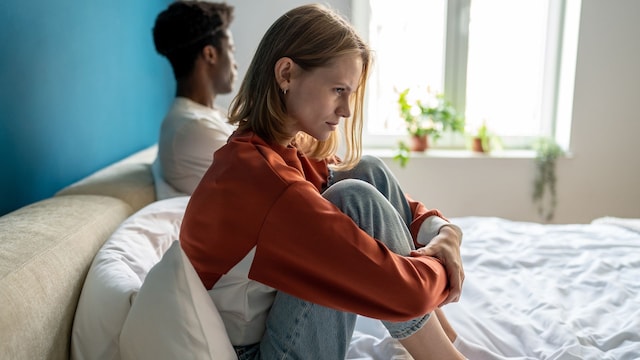 pareja enfadada y triste, sentada en la cama