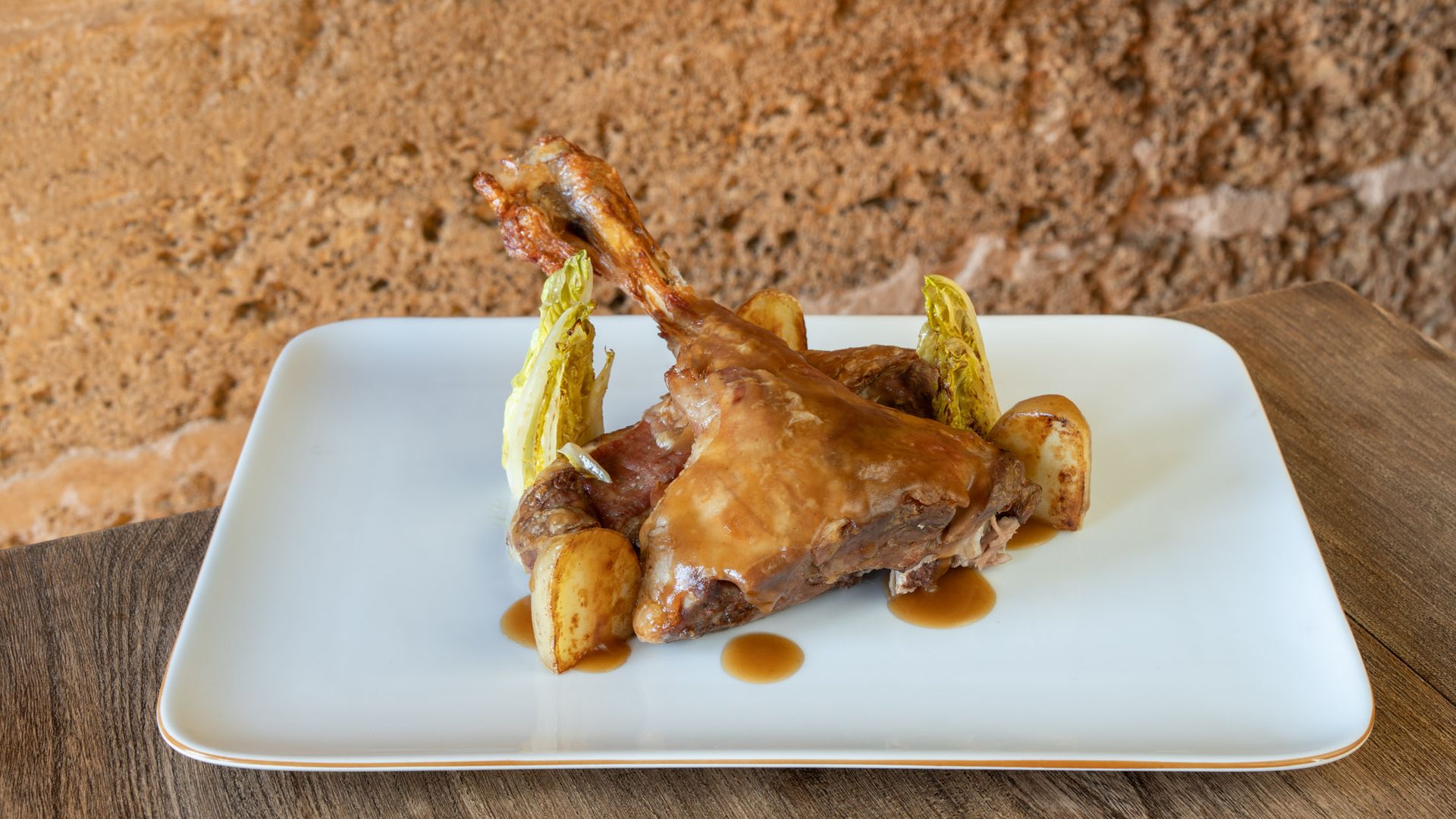 Plato principal: Lechazo asado con patata asada y cogollos braseados, jugoso, aromático e irresistible