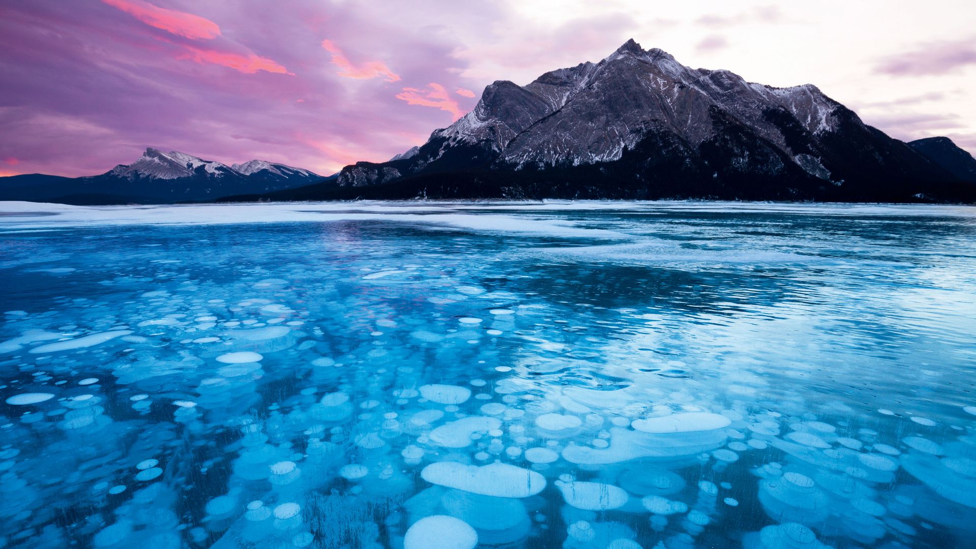 Bajo el hielo del lago Abraham, en Alberta (Canadá), miles de burbujas de metano quedan atrapadas durante el invierno, formando un paisaje único que combina belleza y fenómeno natural.
