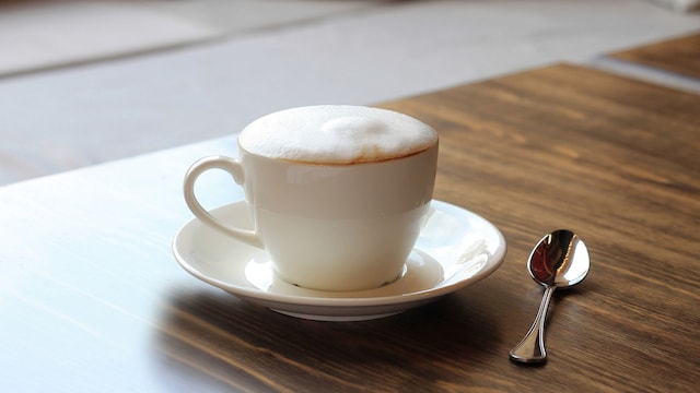 Un café con espuma en una mesa de madera
