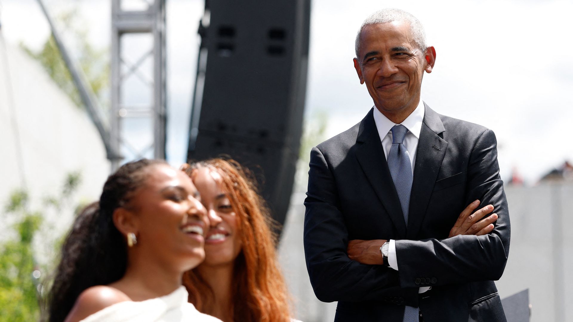 Barack Obama, sonriente al ver una interacción de sus hijas
