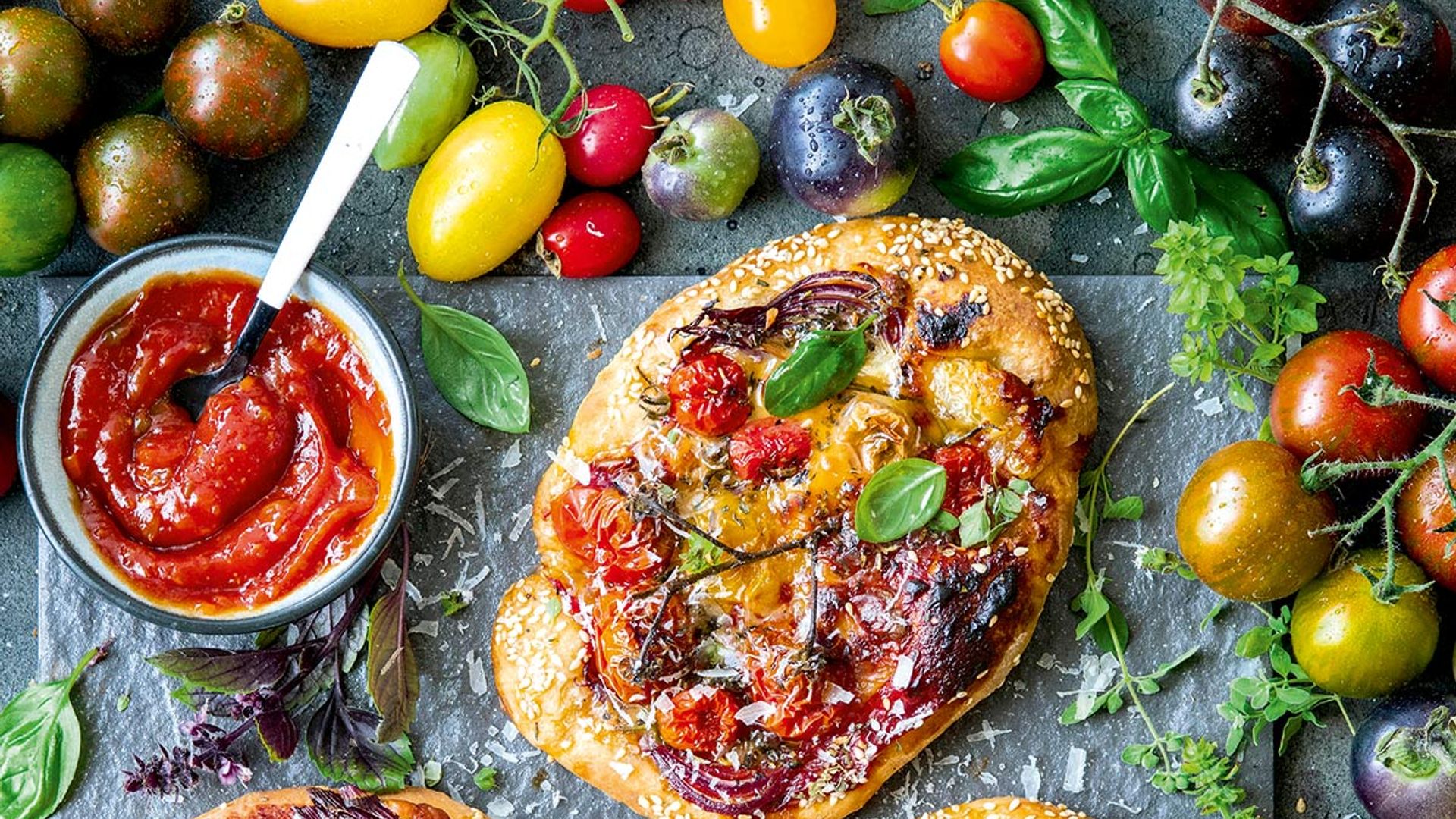 'Pizzetas' de tomates variados con cebolla morada y queso parmesano