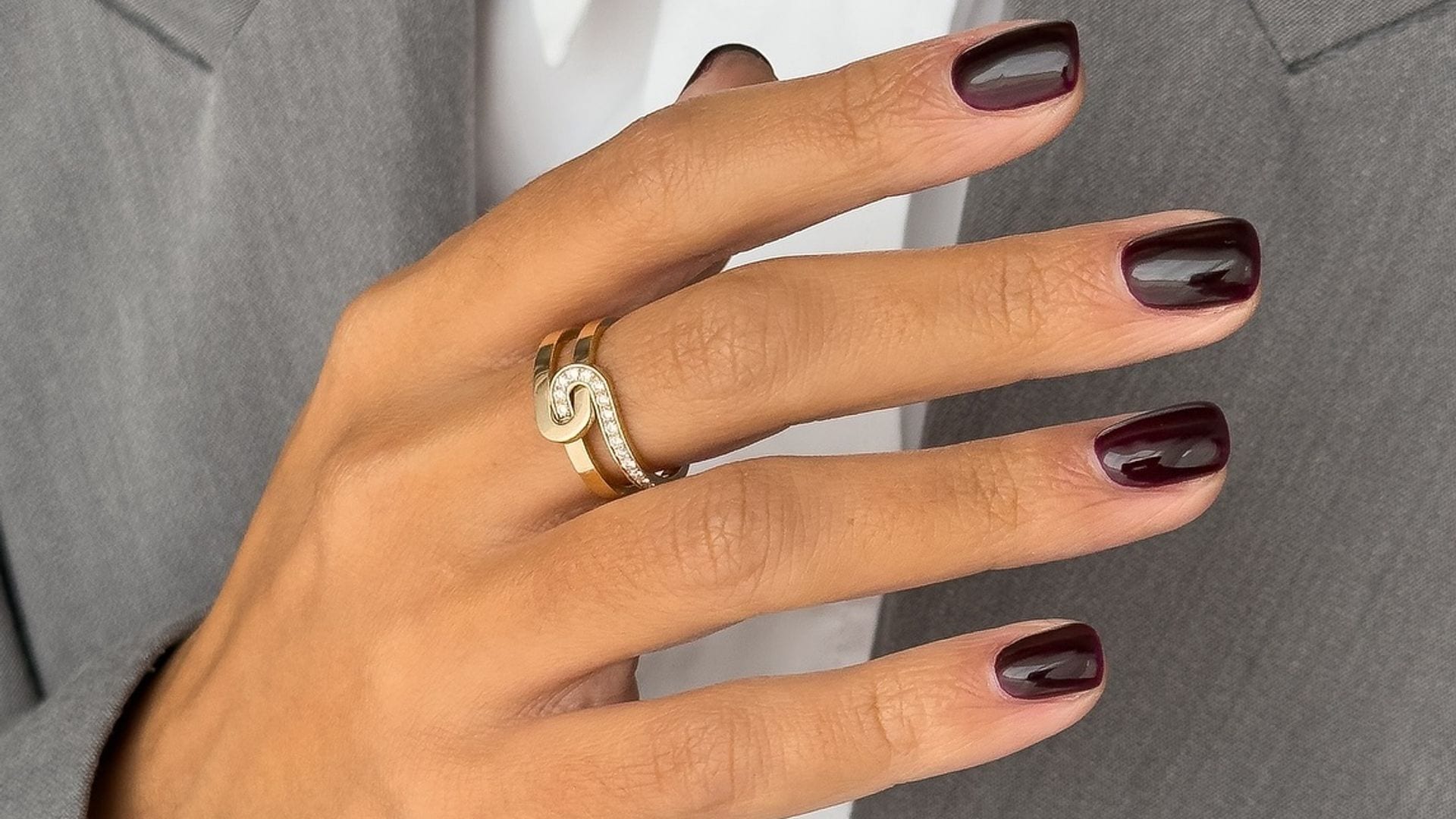 Uñas granates, chaqueta gris y camisa blanca