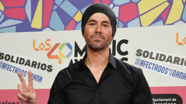 Plano medio de Enrique Iglesias con camisa negra y jeans negros con cadena