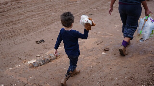 Plano general de un niño y su madre en la DANA de Valencia