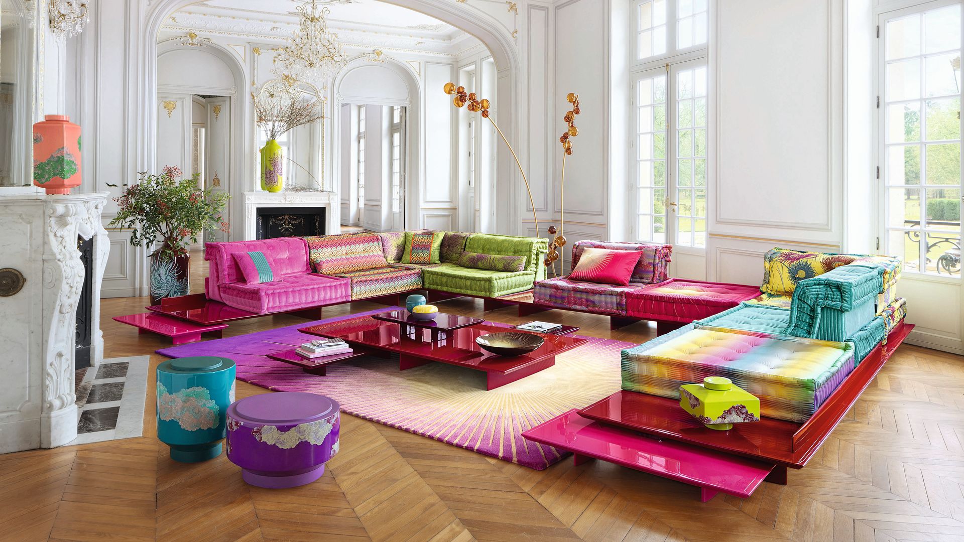 Salón con techo altos y paredes con molduras doradas, sofá Mah Jong con telas de Kenzo Takada
