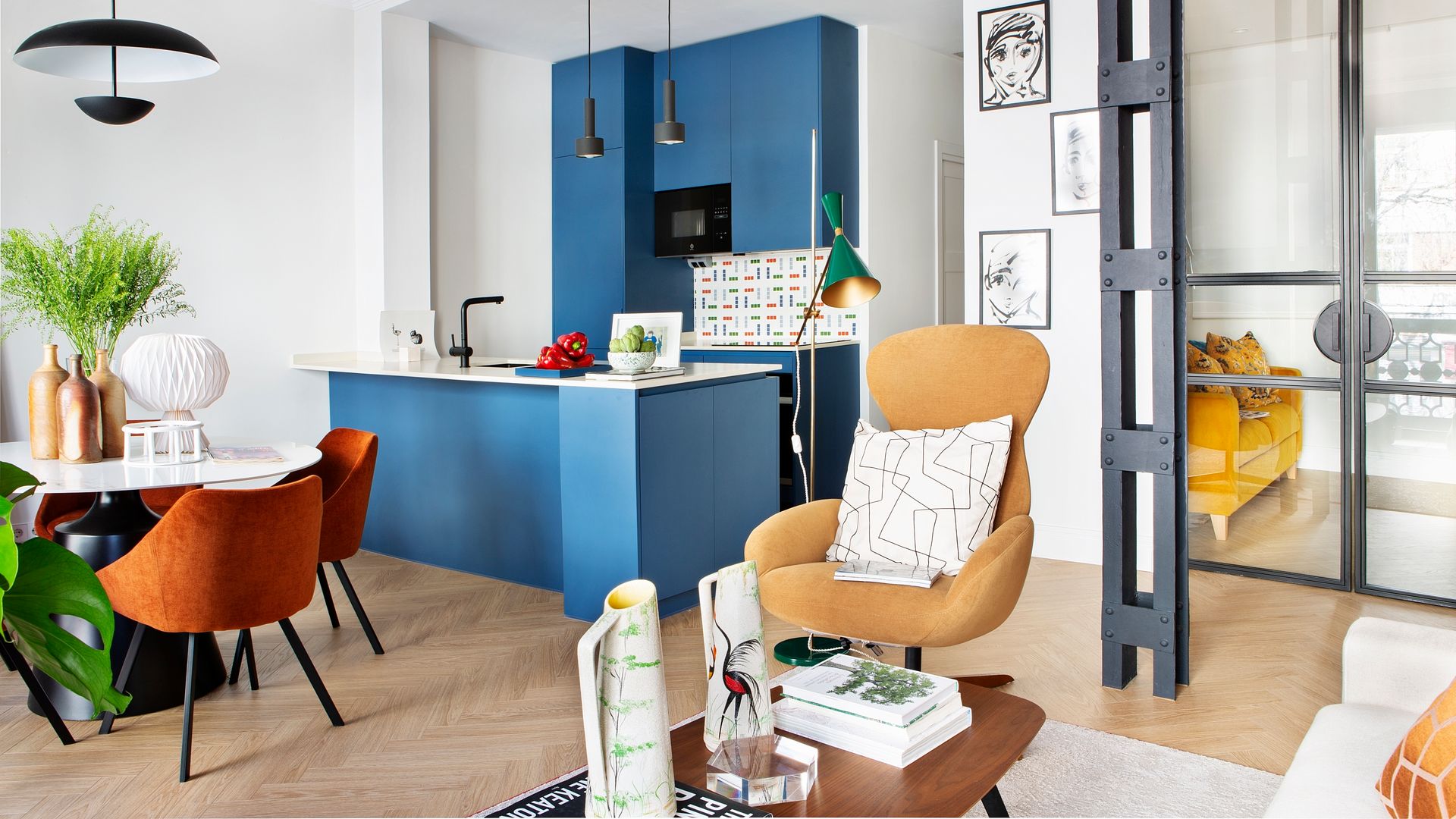 Espacio único con cocina con muebles azules, comedor y salón en uno