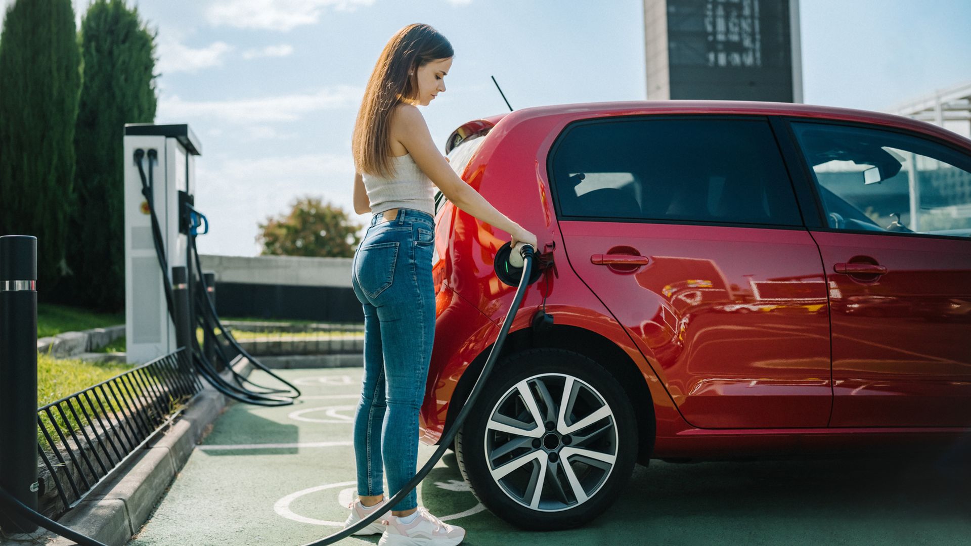 Mujer cargando su coche eléctrico