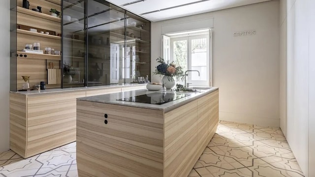 Cocina con isla central de madera con fregadero y cocina integrada