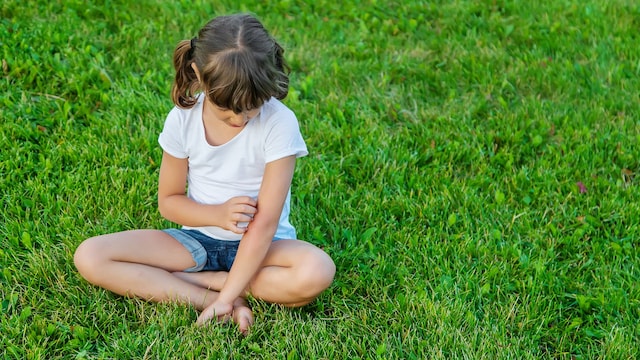Niña se rasca el brazo por la picadura de un mosquito