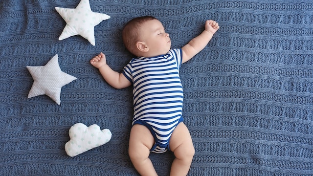 Bebé durmiendo sobre una cama