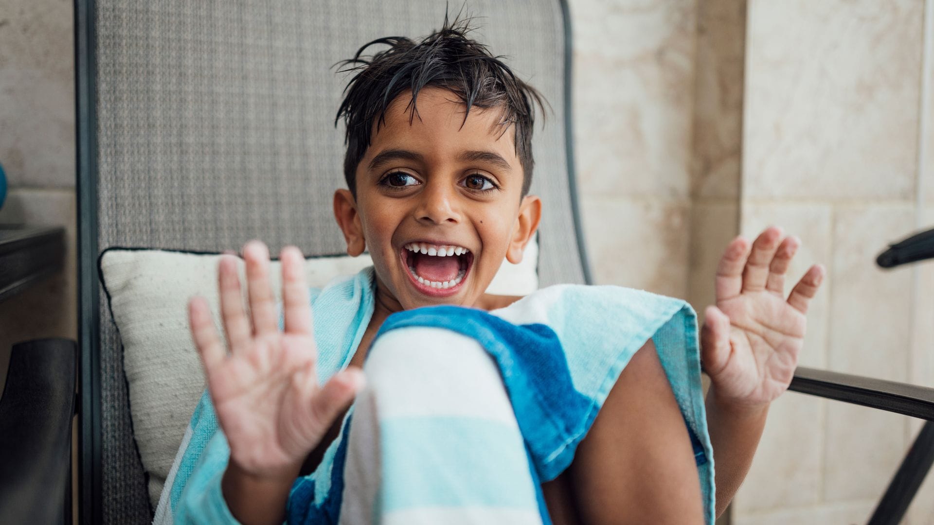 Niño con manos arrugadas por haber pasado mucho tiempo en la piscina