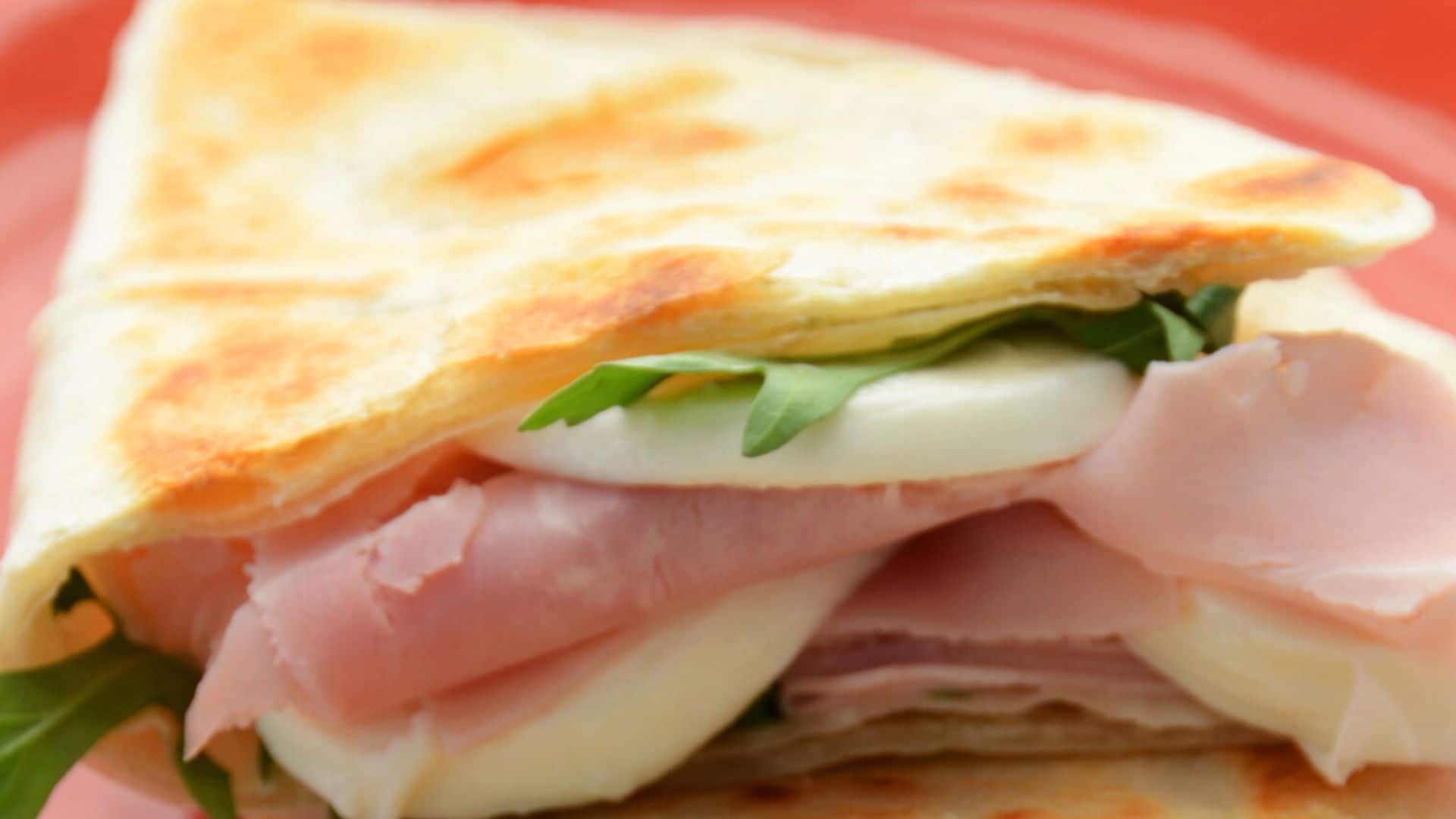 Piadina rellena de mozzarella, jamón, tomate y rúcula