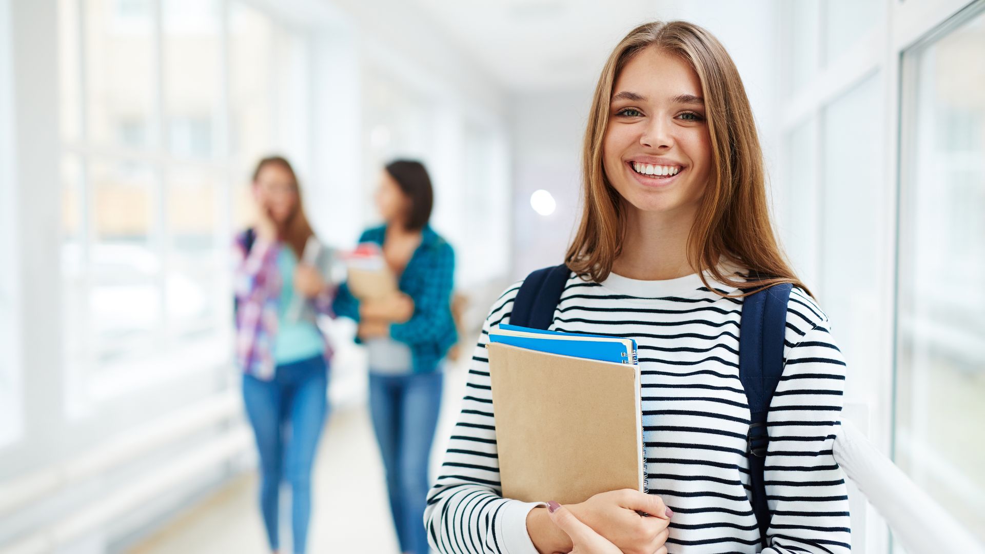 Estudiante universitaria feliz con libros en la mano