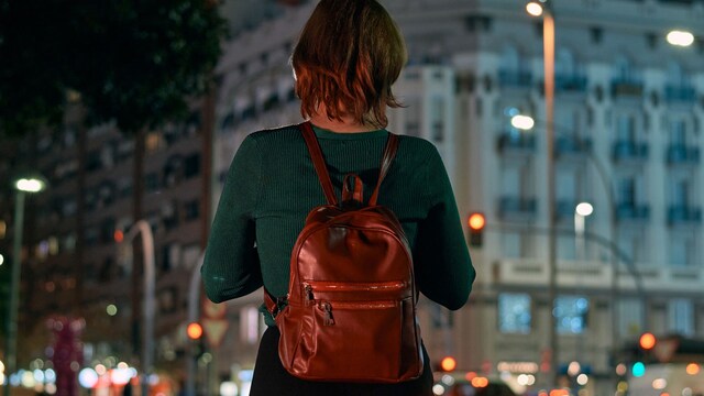 Una mujer paseando sola por la noche