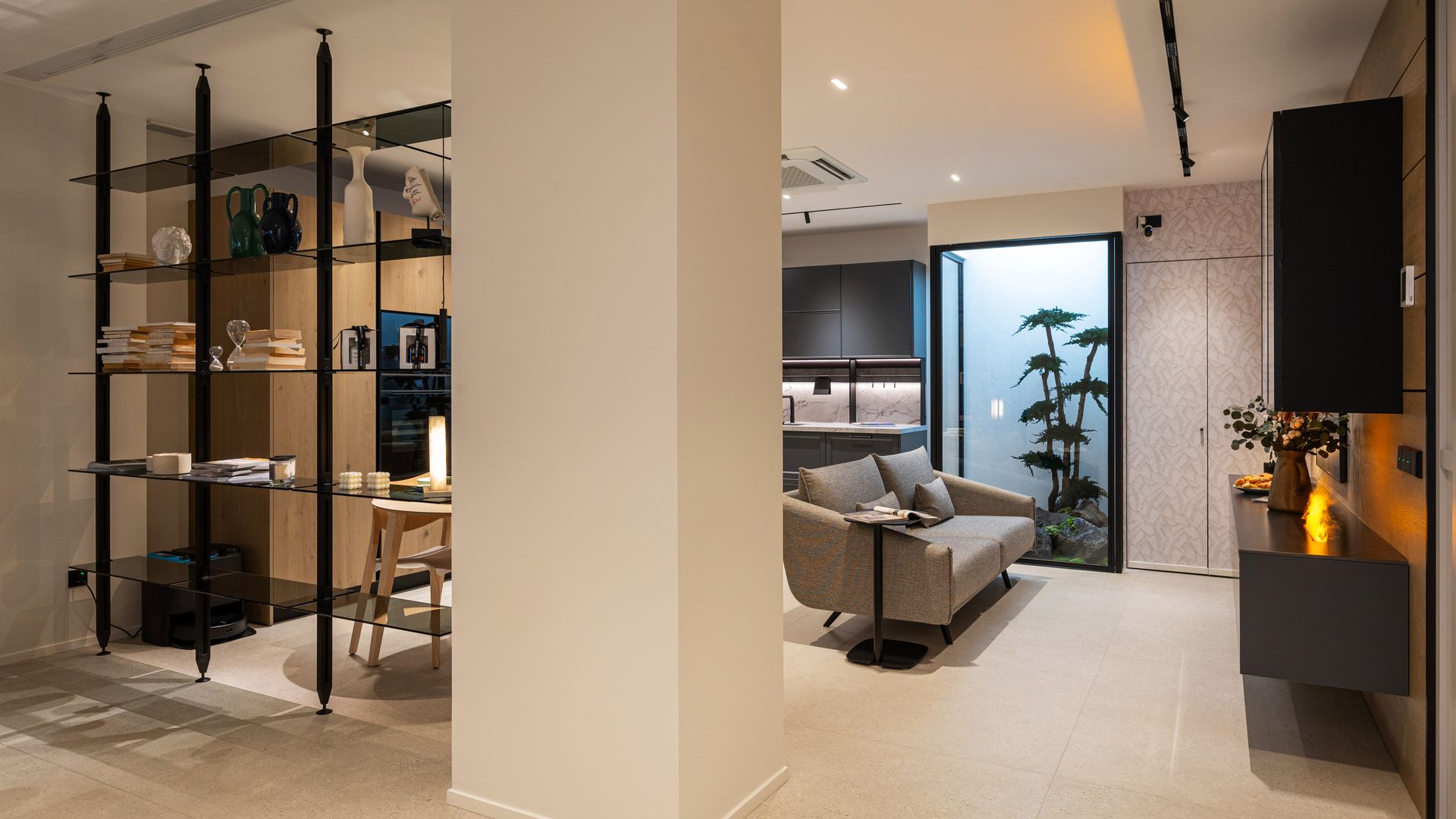 Espacio único con salón comedor y cocina, separado del recibidor mediante una estantería abierta y sin trasera