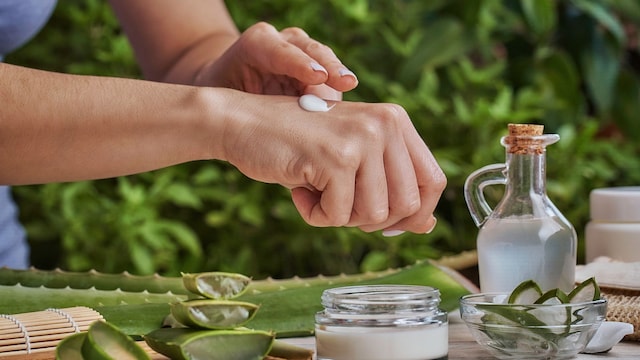 mujer aplicándose una crema de aloe vera en su mano