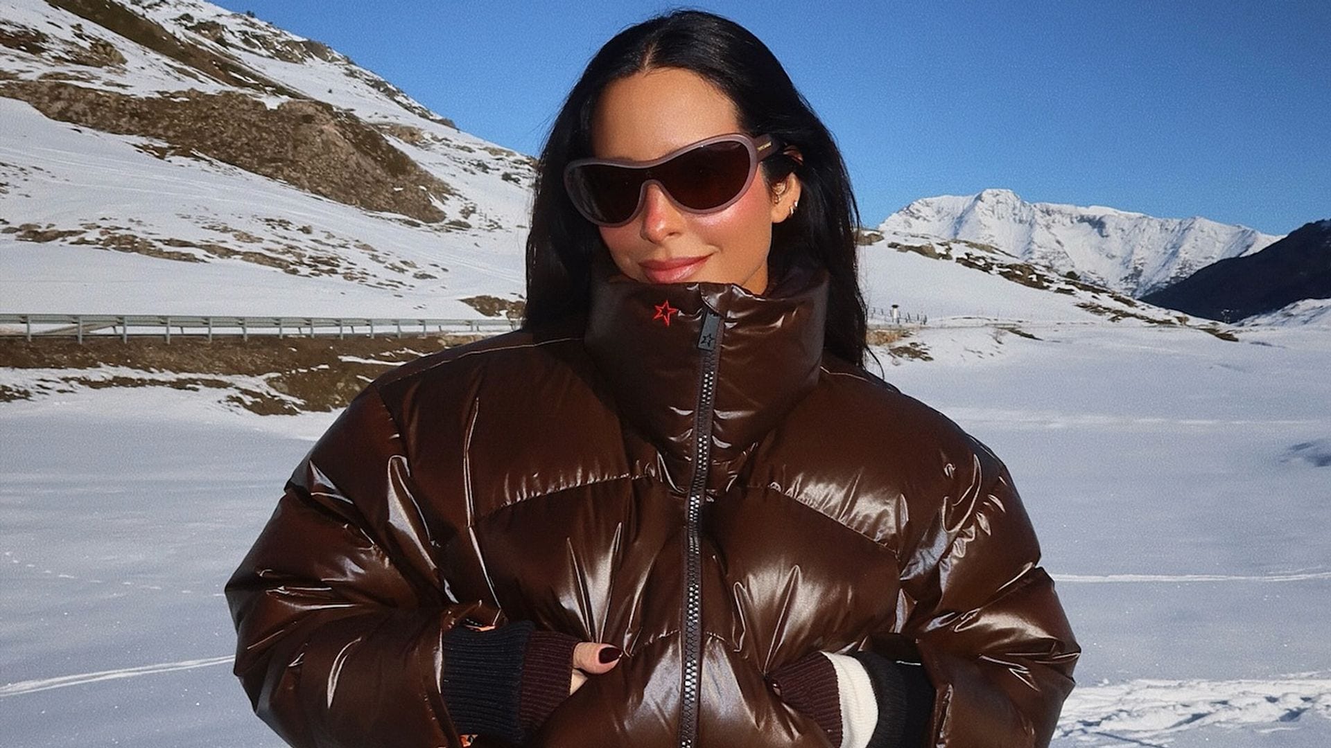 María Fernández Rubíes con cazadora marrón y pantalones de esquí blancos en la montaña