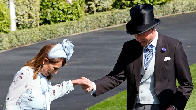 El príncipe de Gales ayuda a su suegra, Carole Middleton, a sacar el tacón de su zapato, que se quedó atrapado en el césped durante el segundo día del Royal Ascot, Inglaterra