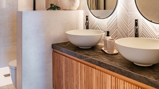 Baño con mueble volado de madera y encimera negra