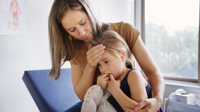 Madre comprueba si su hija tiene fiebre