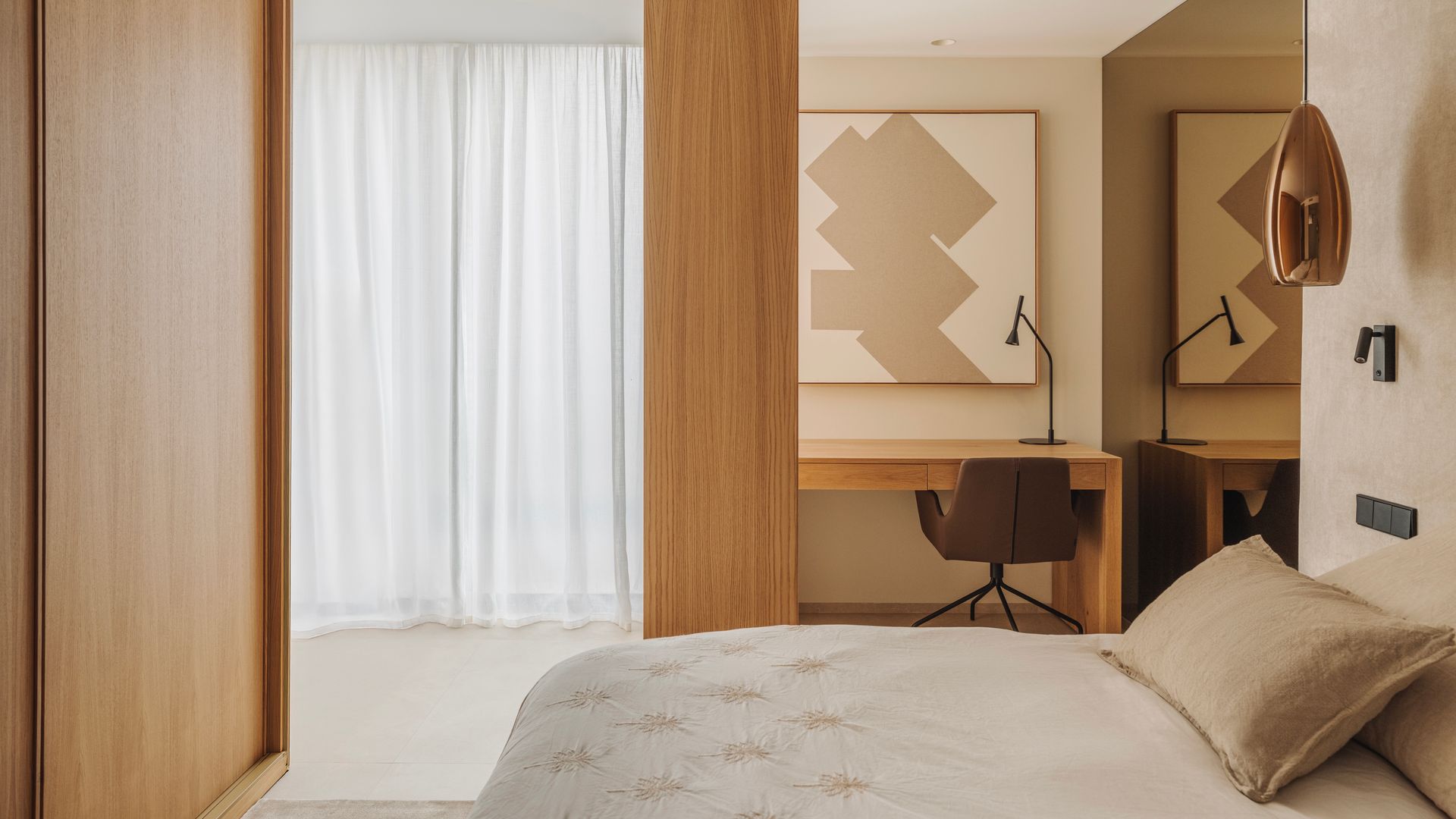 Dormitorio con rincón de escritorio, tonos neutros, columna de madera, pared cabecero papel con textura