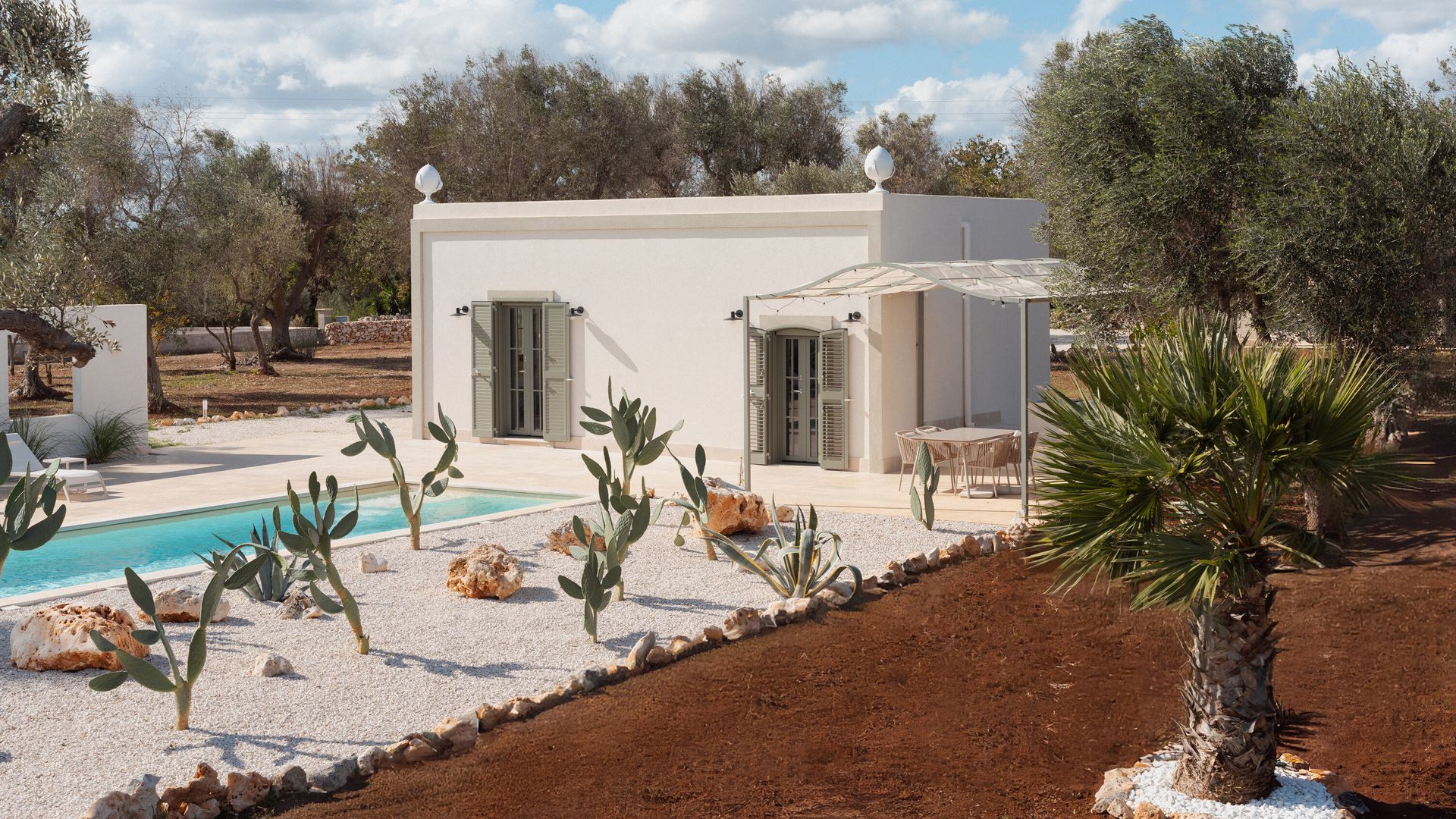 Exterior villa blanca, típica mediterránea, con piscina, cactus, olivos y palmeras