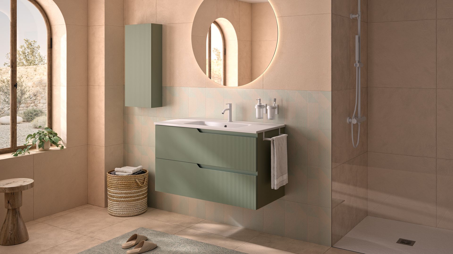 Baño con ducha, ventana, mampara de ducha sin perfiles, mueble de lavabo verde, espejo redondo, armario colgado a juego con el mueble, alfombra