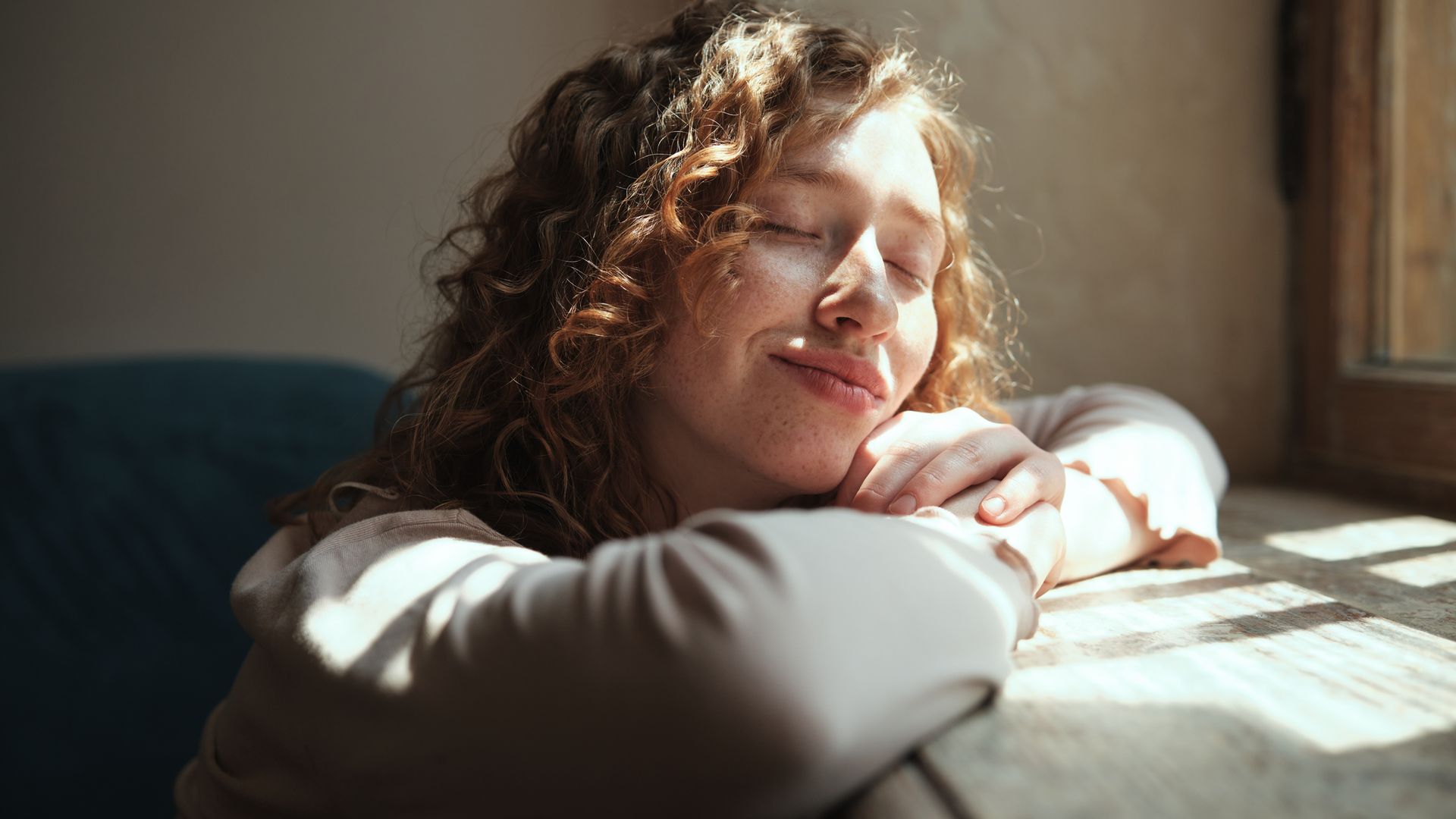 chica apoyada alfeizar ventana