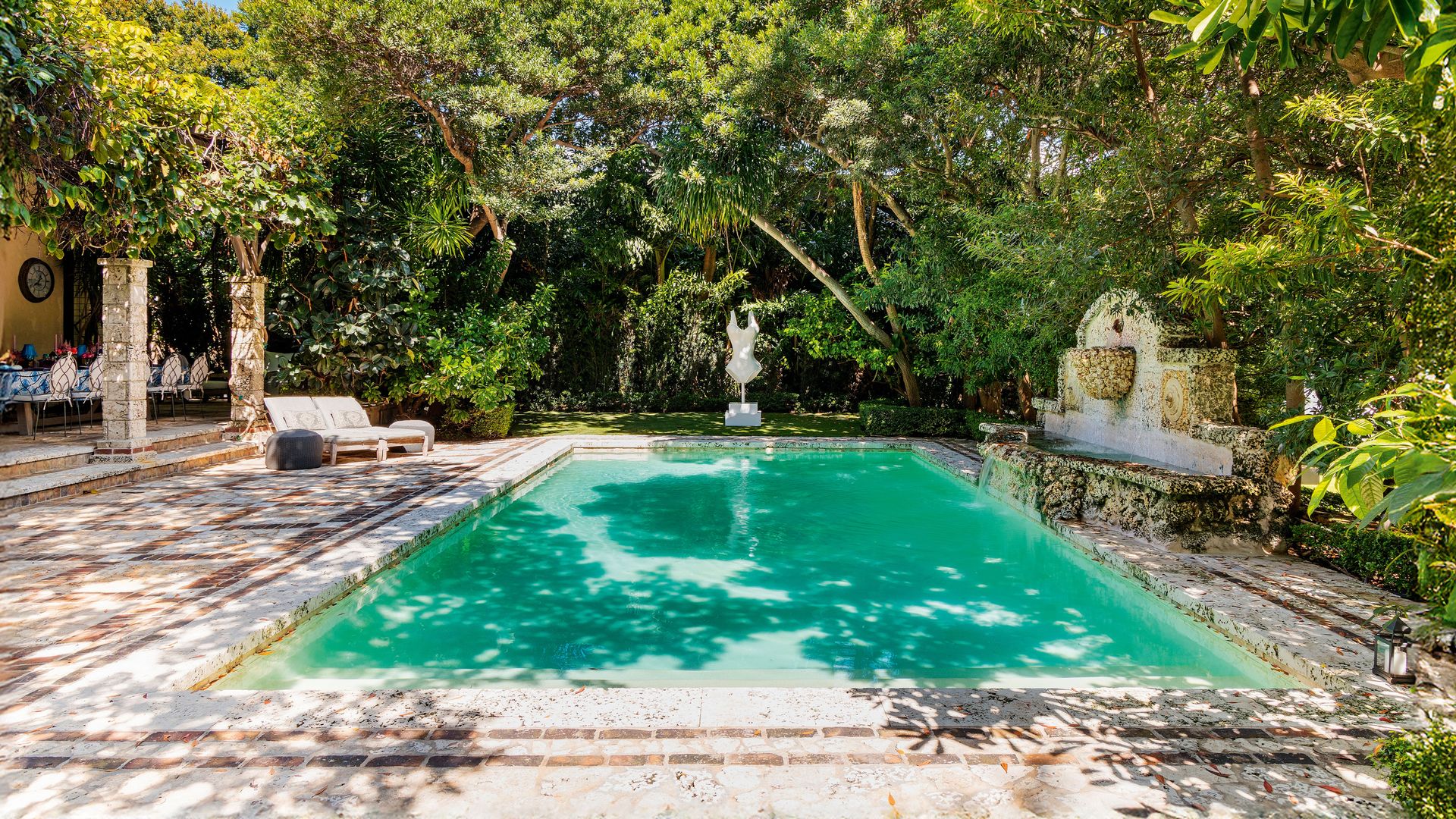 La piscina de azulejos con la escultura "Body Amor", de bronce pintado en blanco, al fondo. D