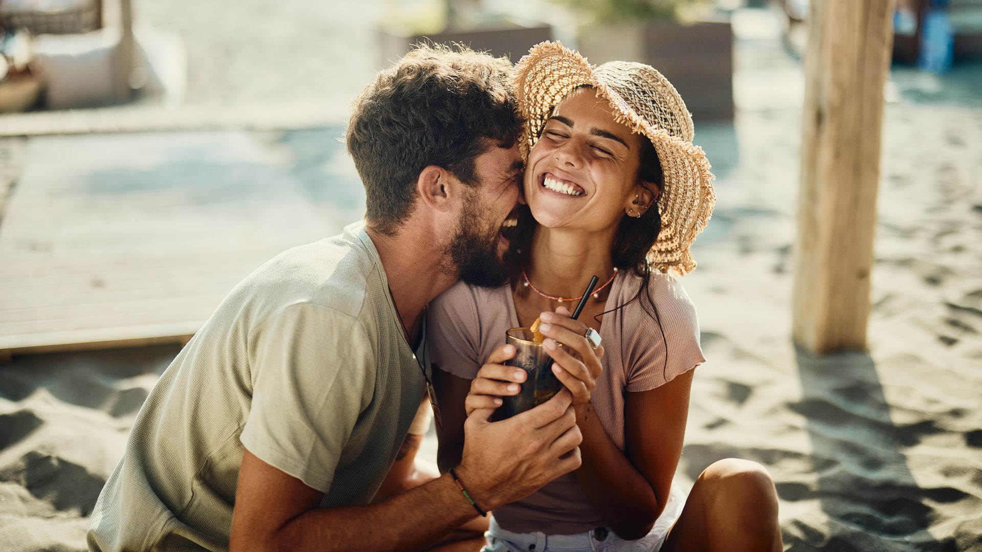 Joven pareja divirtiéndose en la playa 