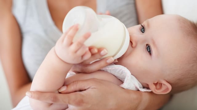 Madre alimentando a su bebé con un biberón anticólico