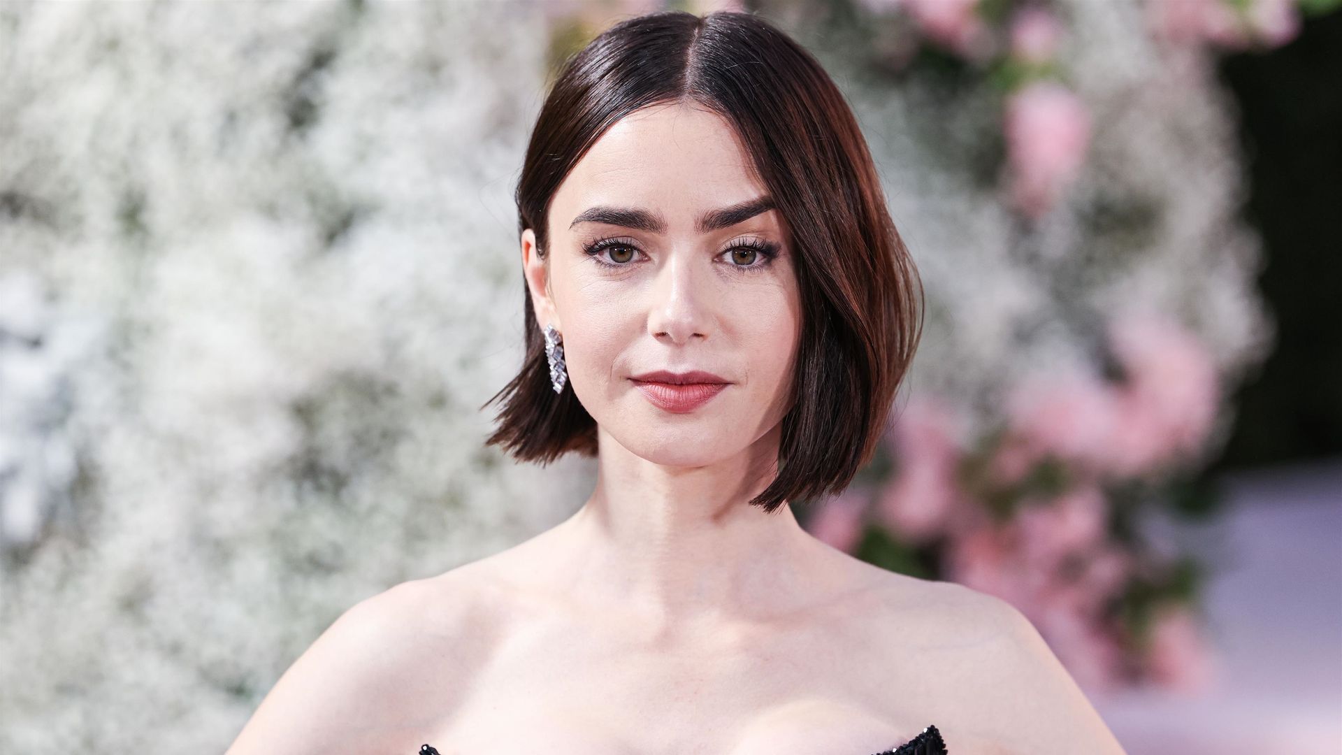 Primer plano de Lily Collins con top encorsetado negro de brillos