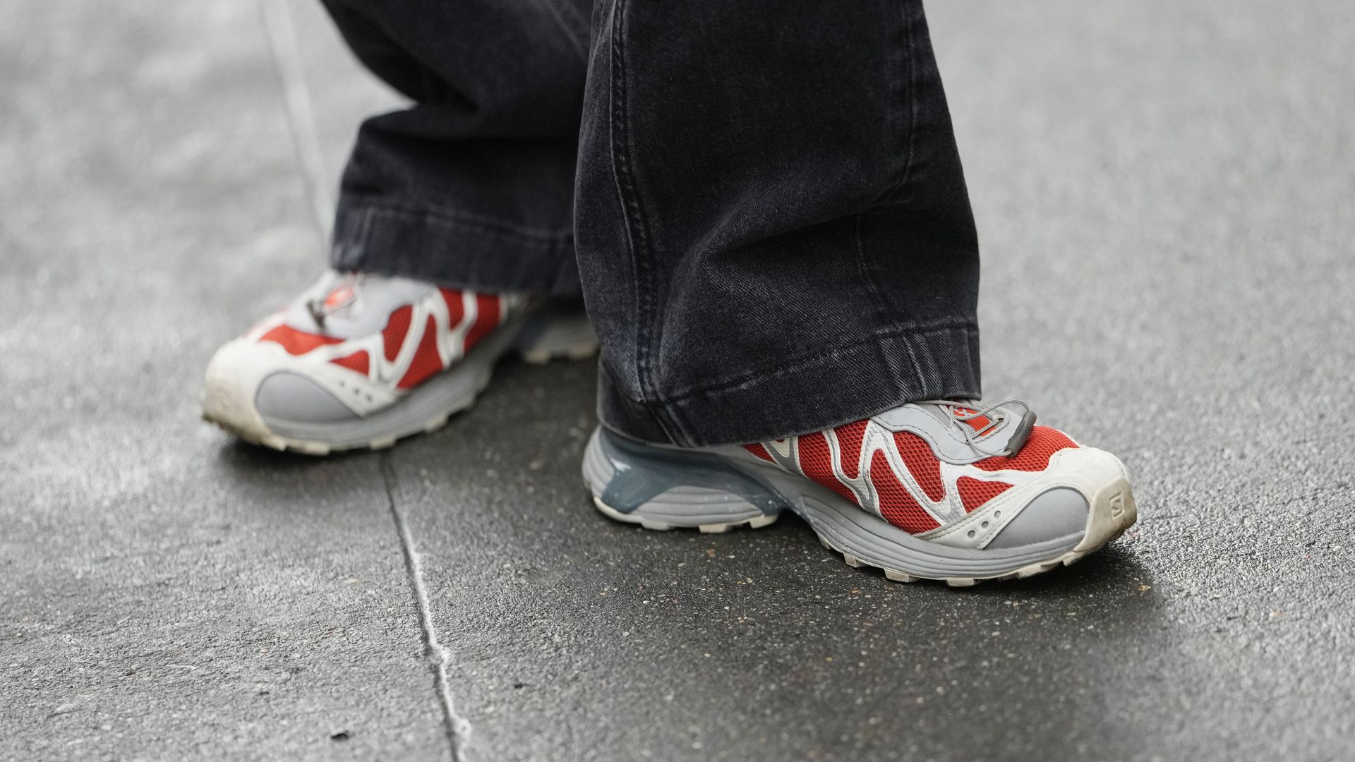 Plano corto a los pies de una mujer con zapatillas de senderismo grises y rojas