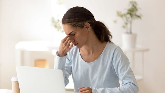 mujer con la vista cansada frente a su ordenador