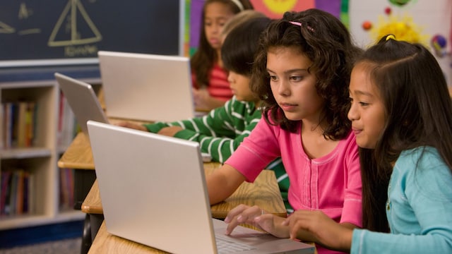 Niños trabajan con un ordenador en clase