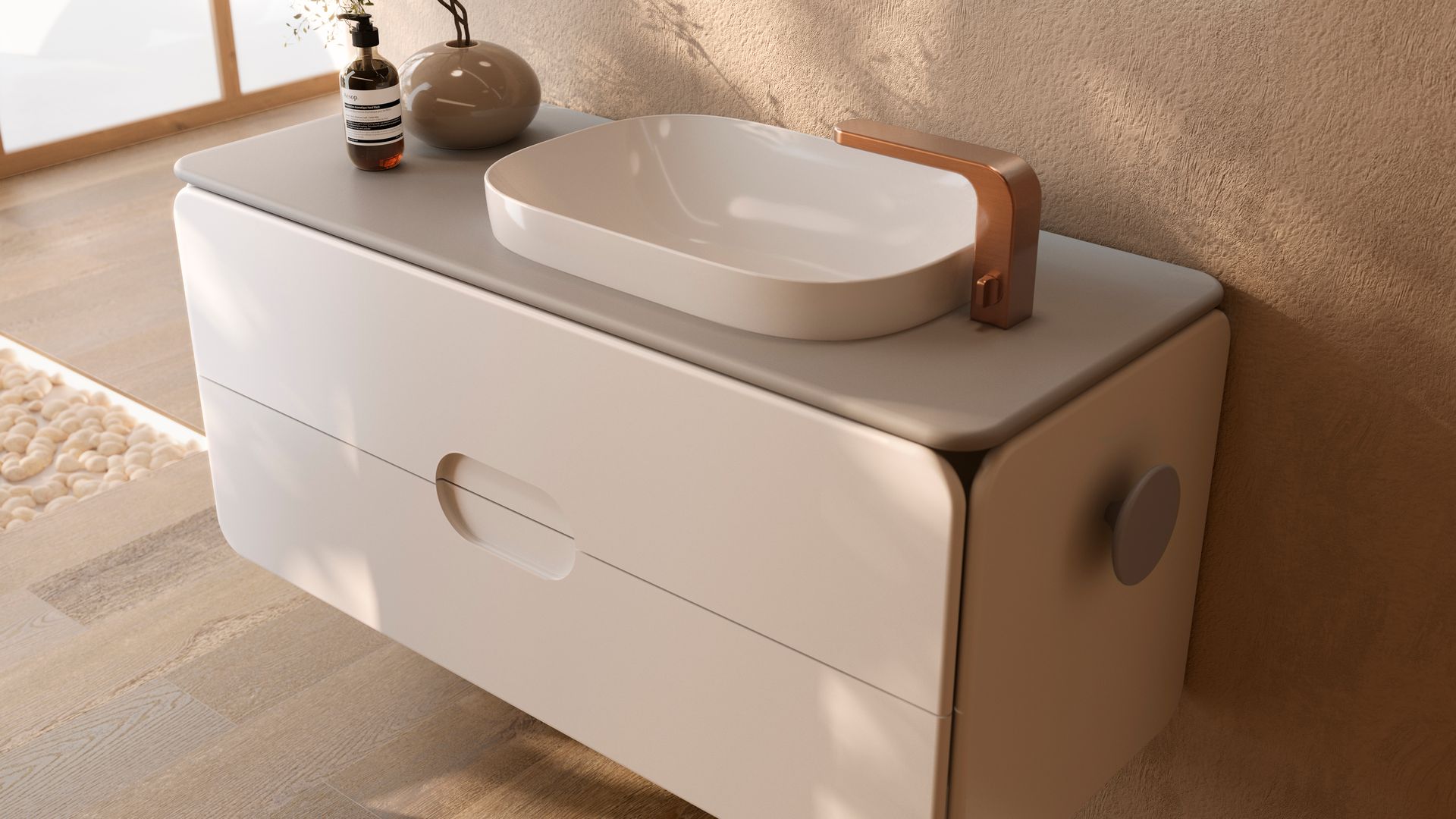 Baño con mueble en color beige con lavabo ovalado, toallero en uno de sus laterales, grifería dorada, ambientador y jarrón 