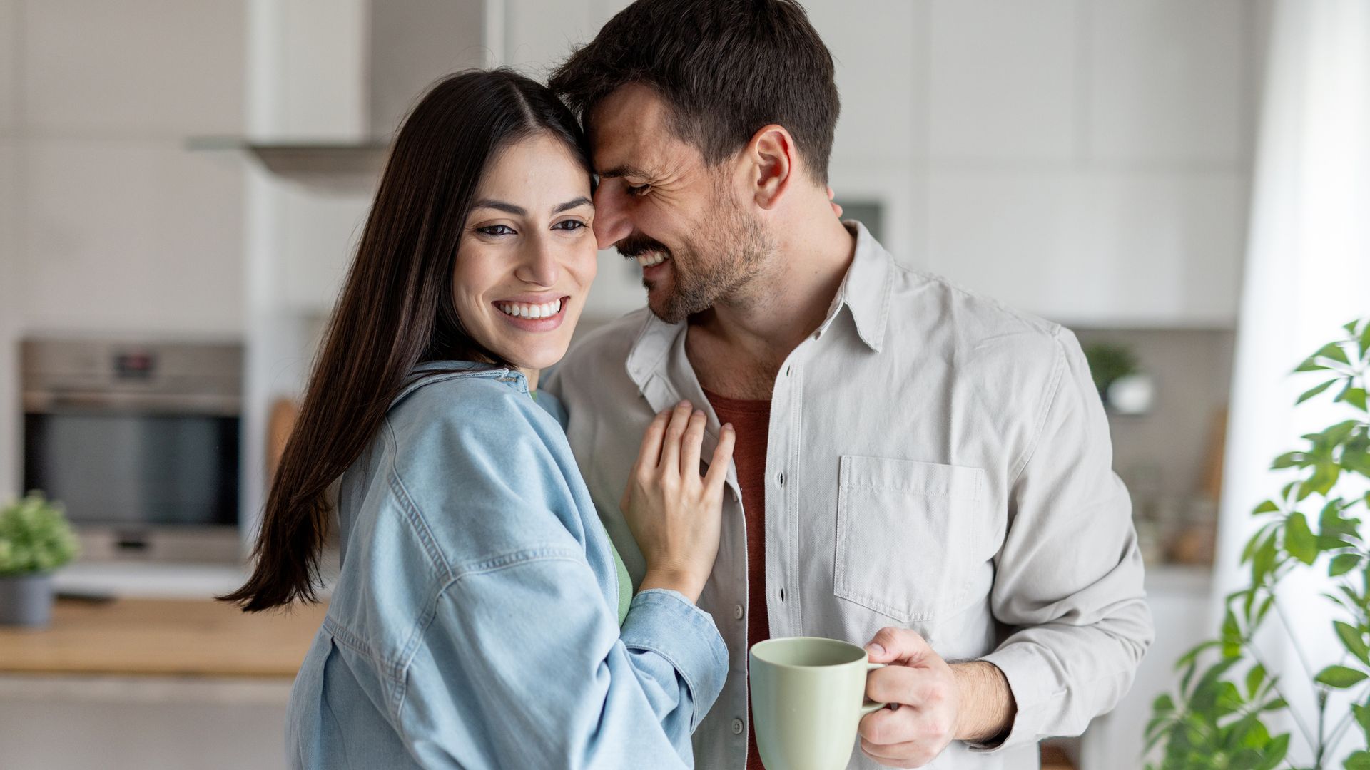 Pareja joven feliz en la cocina en el desayuno