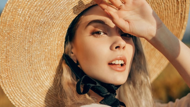 Mujer con sombrero y rostro al sol