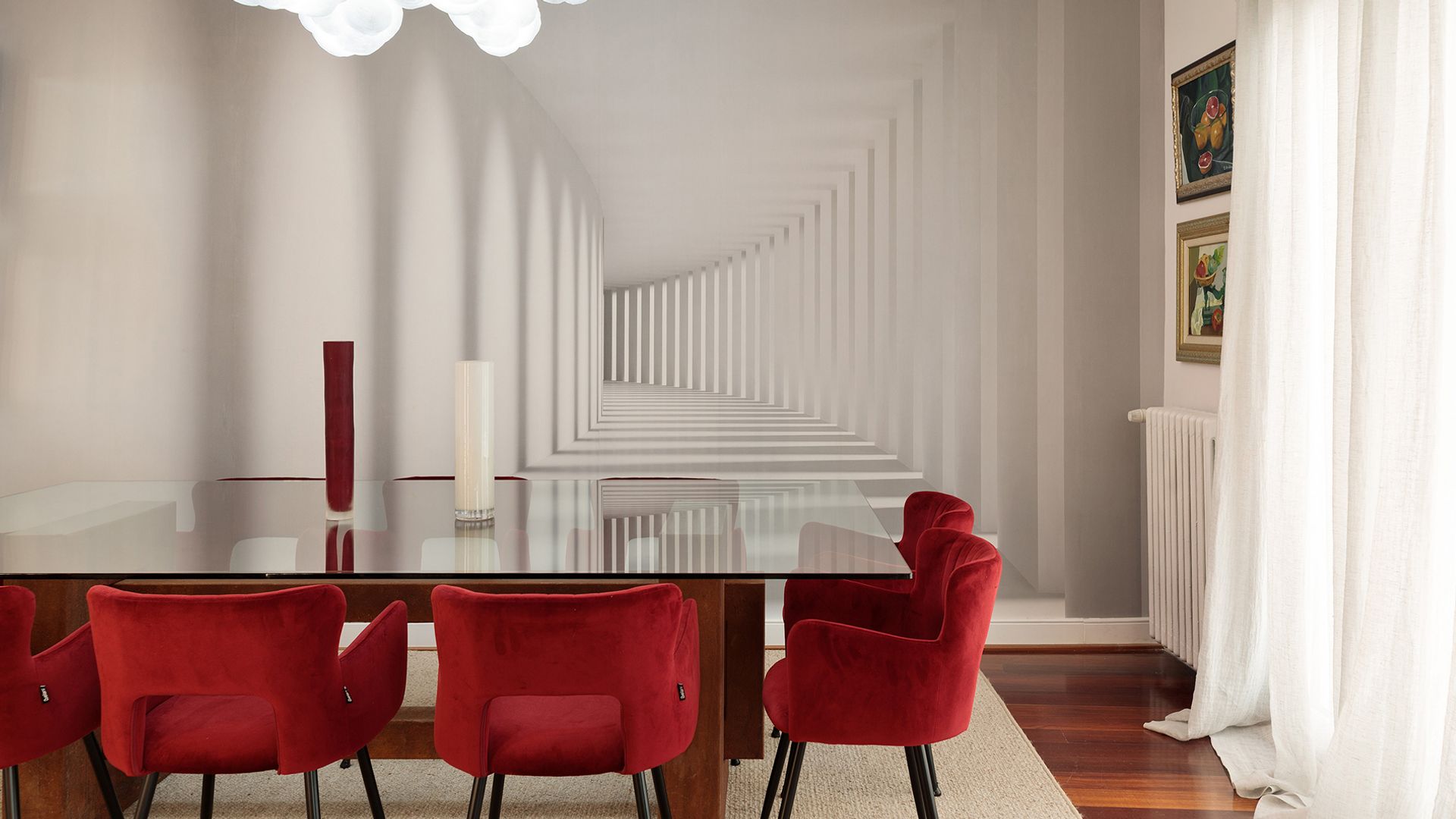 Comedor con sillas rojas, mesa de cristal, alfombra, cortinas blancas, radiador blanco y lámpara de techo